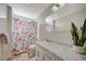 Compact bathroom featuring a vanity with a marble countertop, a floral shower curtain, and a neutral color scheme at 3220 Pawnee Dr, Las Vegas, NV 89169