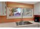 Kitchen sink overlooking the yard with sleek faucet and patterned tile backsplash at 3220 Pawnee Dr, Las Vegas, NV 89169