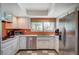Well-lit kitchen with stainless steel appliances, white cabinetry, and a window overlooking the yard at 3220 Pawnee Dr, Las Vegas, NV 89169