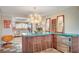 Kitchen island with turquoise counter, unique lighting and seating, plus stainless steel beverage refrigerator at 3220 Pawnee Dr, Las Vegas, NV 89169