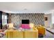 Living room with colorful floral wallpaper, yellow sofas, and a pink credenza featuring modern decor at 3220 Pawnee Dr, Las Vegas, NV 89169