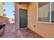 Backyard entryway featuring a brick-paved path, green door, and textured siding for a private outdoor space at 3903 Henny Ave, Las Vegas, NV 89141