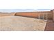 A spacious, bare backyard ready for landscaping and personalization with a brick wall and dog run at 3903 Henny Ave, Las Vegas, NV 89141