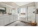 Bathroom featuring double sinks, a soaking tub, and a glass-enclosed shower at 3903 Henny Ave, Las Vegas, NV 89141