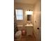 Cozy bathroom with a single vanity, toilet, window with blinds, and modern lighting fixture at 4120 E Cincinnati Ave, Las Vegas, NV 89104