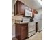 Well-equipped kitchen with white appliances, granite countertops, and dark wood cabinetry at 5138 S Jones Blvd # 207, Las Vegas, NV 89118