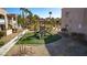 Community playground area with slides and benches in a landscaped setting with mature palm trees at 5166 S Jones Blvd # 202, Las Vegas, NV 89118
