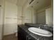 Well-lit bathroom featuring a large mirror, granite countertop and tile floors at 5183 Silica Chalk Ave, Las Vegas, NV 89115