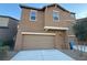 Inviting two-story home featuring a neutral color scheme, a two-car garage and a well-maintained lawn at 5183 Silica Chalk Ave, Las Vegas, NV 89115