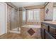 Nicely tiled bathroom featuring a tub, shower with glass door, and white shutters at 6136 Stanton Summit Dr, North Las Vegas, NV 89081