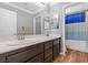 Bright bathroom featuring double sinks, wood floors, and a shower with blue accents at 6136 Stanton Summit Dr, North Las Vegas, NV 89081