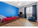 Cozy bedroom with blue accent wall, tiled floor, and a large window with natural light at 6136 Stanton Summit Dr, North Las Vegas, NV 89081