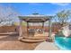 This backyard has a gazebo with seating that sits next to a private pool with a slide at 6136 Stanton Summit Dr, North Las Vegas, NV 89081