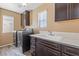 Functional laundry room with dark cabinetry, sink, and modern appliances for convenience at 6136 Stanton Summit Dr, North Las Vegas, NV 89081