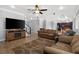 Open-concept living area with tile floors, large TV, and staircase at 6136 Stanton Summit Dr, North Las Vegas, NV 89081