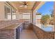 Inviting outdoor kitchen with stone accents, granite countertops, and built-in grill at 6136 Stanton Summit Dr, North Las Vegas, NV 89081