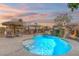 Resort-style pool with rock waterfall, gazebo and lounge chairs against a colorful sunset sky at 6136 Stanton Summit Dr, North Las Vegas, NV 89081