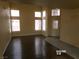 Spacious living room with wood-look flooring, neutral walls, and large windows at 8379 Drop Camp St, Las Vegas, NV 89123