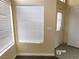 Bright living room featuring multiple windows with blinds and a stylish entry door at 8379 Drop Camp St, Las Vegas, NV 89123