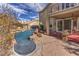 Backyard oasis featuring a custom pool with rock accents and a covered patio for relaxing outdoors at 8953 Belconte Ln, Henderson, NV 89074