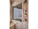 Tiled walk-in shower with dual shower heads, bench and glass block window offering natural light to the soaking tub at 8953 Belconte Ln, Henderson, NV 89074