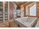 Bathroom featuring a soaking tub, glass block window, tiled shower with glass door, and built-in linen storage at 8953 Belconte Ln, Henderson, NV 89074