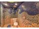 Mosaic tiled shower and toilet area with a unique ocean wave design and glass shower door at 8953 Belconte Ln, Henderson, NV 89074