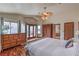 Bright bedroom featuring wood flooring, palm fan, dresser and a full bath and balcony beyond at 8953 Belconte Ln, Henderson, NV 89074