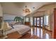 Light-filled bedroom with tropical mural, wood floors, and access to a private balcony at 8953 Belconte Ln, Henderson, NV 89074