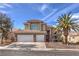 Inviting two-story home featuring a three-car garage, mature landscaping and a beautiful palm tree at 8953 Belconte Ln, Henderson, NV 89074