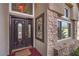 Close-up of an elegant stained wood front door, with decorative glass and wrought iron security gate at 8953 Belconte Ln, Henderson, NV 89074