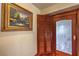 Hallway featuring custom wood cabinets, framed art and decorative glass inlay door at 8953 Belconte Ln, Henderson, NV 89074