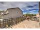 Spacious outdoor patio area with iron railing, a view of surrounding houses, and a chimenea fireplace at 8953 Belconte Ln, Henderson, NV 89074