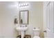 Powder room features a pedestal sink, decorative mirror, and a standard toilet at 909 Cirrus Cloud Ave, Las Vegas, NV 89138