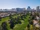 Scenic aerial view of the community with lush green golf course and city buildings on the horizon at 914 Tam O Shanter, Las Vegas, NV 89109
