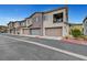 View of townhome exteriors with attached garages, displaying modern architecture and individual unit entrances at 965 Nevada State Dr # 38202, Henderson, NV 89002