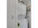 Compact laundry closet with stacked washer and dryer, efficient space-saving design, and storage for cleaning supplies at 965 Nevada State Dr # 38202, Henderson, NV 89002