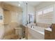 Well-lit bathroom featuring a soaking tub, a walk-in shower with a bench, and neutral-toned tile at 10500 Pacific Palisades Ave, Las Vegas, NV 89144