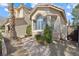 Close-up of home's exterior showcasing the architectural details, stone path, and lush greenery at 10500 Pacific Palisades Ave, Las Vegas, NV 89144