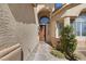 Inviting entryway with a stylish front door, decorative plants, and elegant architectural accents at 10500 Pacific Palisades Ave, Las Vegas, NV 89144