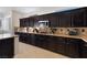 Kitchen with dark wood cabinets, long granite counters and ample space at 10500 Pacific Palisades Ave, Las Vegas, NV 89144