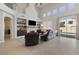 Open-concept living room featuring a fireplace, built-in shelving, and lots of natural light overlooking the pool at 10500 Pacific Palisades Ave, Las Vegas, NV 89144