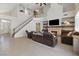 Bright living room with high ceilings and fireplace adjacent to the stairs leading to the second floor at 10500 Pacific Palisades Ave, Las Vegas, NV 89144