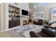 Bright living room features a stone fireplace, built-in shelving, and vaulted ceilings with ample natural light at 10500 Pacific Palisades Ave, Las Vegas, NV 89144