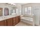 Well-lit bathroom featuring double sinks, soaking tub, and a separate shower at 11178 Corsica Mist Ave, Las Vegas, NV 89135