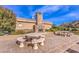 Community fireplace seating area with stone fireplace and picnic table for gatherings and outdoor entertaining at 11178 Corsica Mist Ave, Las Vegas, NV 89135