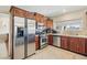 Well-lit kitchen with stainless steel appliances, tile flooring, and wooden cabinets at 1912 Parkchester Dr, Las Vegas, NV 89108