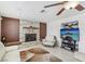 Bright living room featuring a stone fireplace, ceiling fan, and modern furnishings at 1912 Parkchester Dr, Las Vegas, NV 89108