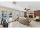 Cozy living room with a stone fireplace, tile floors, modern ceiling fan, and access to the backyard pool at 1912 Parkchester Dr, Las Vegas, NV 89108