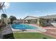 Backyard oasis with pool, slide, and grassy area, perfect for relaxation and play at 1912 Parkchester Dr, Las Vegas, NV 89108